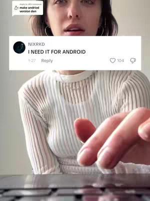 A woman with dark hair is the primary subject, framed from the chest up. Her eyes are wide and focused. Below her, a hand rests on what appears to be a laptop or keyboard, with the fingers slightly curved. A white box with black text overlays her face, displaying a comment and interaction details. The overall composition is a medium shot, emphasizing both facial expression and an element of interaction.
