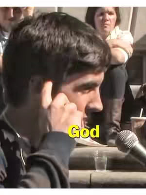 The cover image shows a man in profile, speaking into a microphone. A yellow text overlay reads "God". Other people are visible in the background.