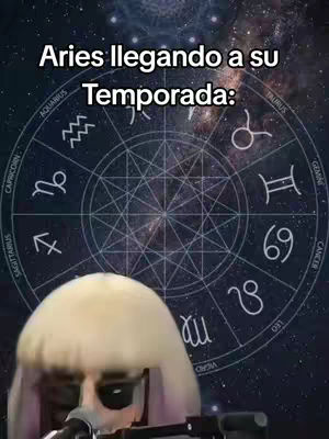 The cover image features a background representing a starry sky with a zodiac wheel in the center. Overlaid on this is a figure with light-colored hair and sunglasses, appearing in the lower portion of the frame. Text "Aries llegando a su Temporada" is at the top.