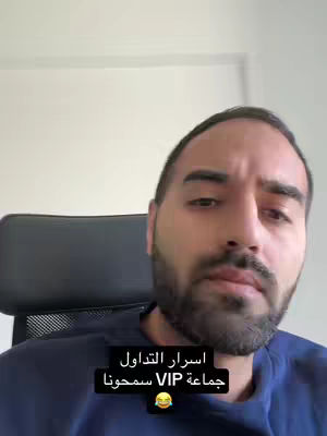 A medium shot shows a man in a blue shirt seated in front of a plain wall. He has a beard and dark hair, and he is looking towards the camera. A text overlay appears at the bottom, set against a black rectangular background.