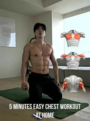A man kneels on a green exercise mat in a well-lit room. The man is shirtless, revealing a muscular physique, and is looking upwards. Overlayed on the image are three anatomical diagrams illustrating chest and arm muscles. Text at the bottom announces a '5 MINUTES EASY CHEST WORKOUT AT HOME.' The room is modern with a large window. The overall aesthetic is aimed at fitness and workout content.