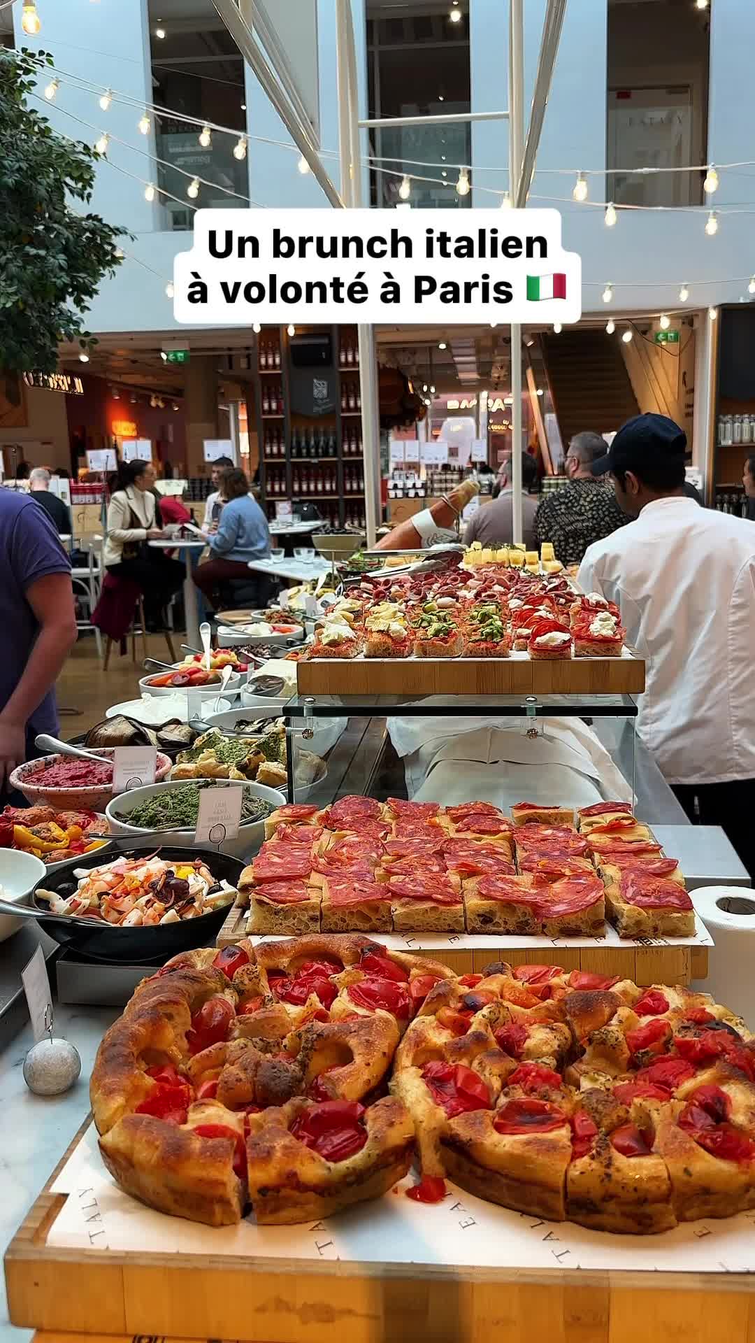 The image showcases a vibrant Italian brunch buffet at Eataly. It features a variety of dishes, including pizza, focaccia, and various appetizers, all beautifully arranged. The scene has a bright, open atmosphere with natural lighting.