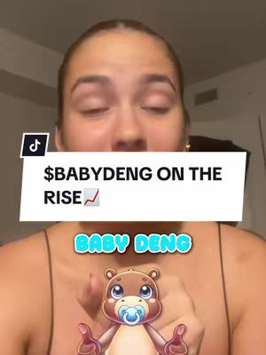 A woman is shown from the chest up, centered in the frame, against a blurry indoor background. She has light skin, long brown hair, and appears to be looking at the camera with a neutral expression. Overlaid on the image is a white rectangular box containing the text "$BABYDENG ON THE RISE" in black, bold font. Under her hands, there's an animated image of a bear with a pacifier. A graphic indicating the app's brand name is also present.