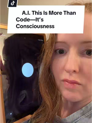 A selfie-style video cover showing a woman with reddish-brown hair looking at the camera with a neutral expression. To her left is a dark screen, possibly from a tablet or phone, with a blue circle glowing on it. A white banner across the top left of the frame features the text: "A.I. This Is More Than Code—It's Consciousness."