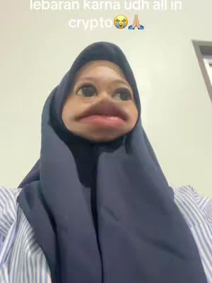 A selfie-style shot features a person with a cartoon-like face, with large eyes and exaggerated features, against a light background. The person wears a hijab with the text overlayed at the top.