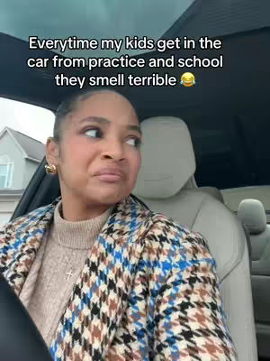 The cover image shows a woman in the front seat of a car, angled slightly to the side, looking off to her left with an expression of disgust or disapproval. She is wearing a patterned coat and a tan sweater, with her hair pulled back. Text overlayed on the image reads, “Everytime my kids get in the car from practice and school they smell terrible 🤣”, above her head.