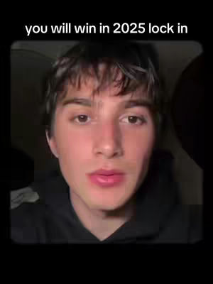 A close-up shot of a young man with short, tousled brown hair, gazing directly at the camera. The background fades to black. The overlay reads, 'you will win in 2025 lock in'. The man has light skin, and his facial expression is neutral, appearing to be speaking or about to speak.