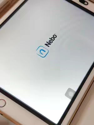 An iPad screen displaying the logo of the Nebo app. The app's logo, a stylized 'n' inside a blue square, is centered on a white background. The iPad is angled diagonally, with its black frame visible around the screen.