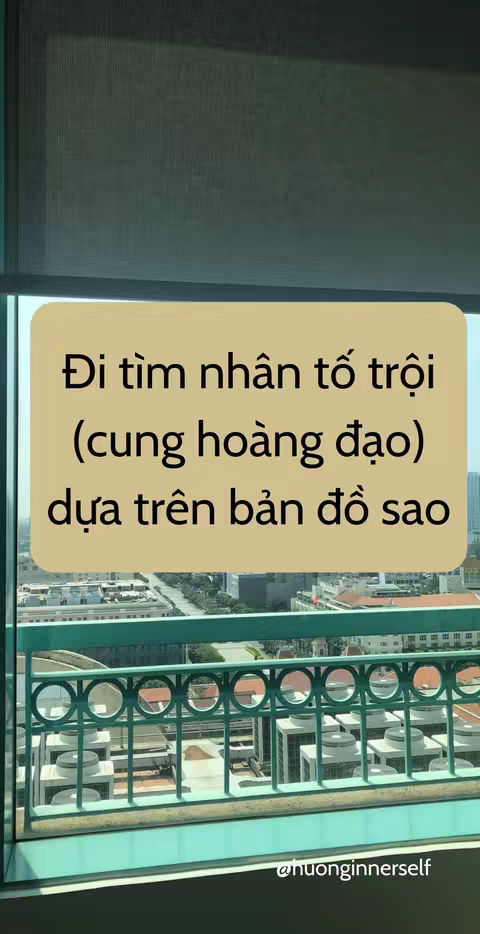 The image shows a view from a window, with cityscape visible through the glass. A large, beige or light-brown rectangular text overlay is superimposed in the foreground, displaying Vietnamese text. Below the text overlay, a green railing stands out. The overall composition is well-lit and clean.
