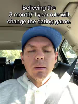 A man in a blue cap is sitting in a car. Text overlayed on the top of the image saying, 'Believing the 3 month/ 1 year rule will change the dating game'.