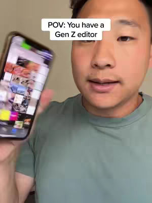 A man holds a phone displaying various interface elements, while the camera focuses on his face. The background is an out-of-focus, neutral-colored interior.