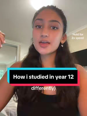 A young woman with long, wavy dark hair is filmed from the chest up against a blurred background. She has fair skin, brown eyes, and is speaking. A colored text box is positioned across the bottom that reads, 'How i studied in year 12 (differently)'. To the right of her head, text indicates that users hold for 2x speed to be engaged.