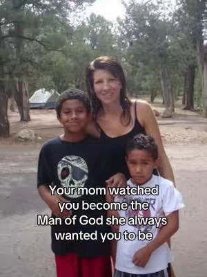 A vertical shot of a family, set outdoors with a forest backdrop. A woman stands in the center, flanked by two boys. Text is overlaid on the image. The family appears to be light-skinned and dressed in casual attire. The background includes trees, suggesting a park or recreational area with a tent visible.