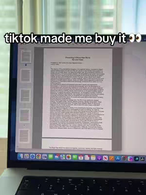 A laptop screen displaying a document is the focus of the image. The document, likely a paper or report, fills a large portion of the screen with text. Above the screen, a white text overlay reads "tiktok made me buy it". The setup suggests a student setting, potentially related to study or academic work, with the background appearing to be a typical living space.