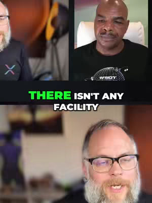 The image is a split screen of two different video feeds that appear to be a call between multiple men. The top right shows a bald black man in a black shirt. The left side shows a man with glasses and a beard. The bottom portion is a video feed of the man with glasses talking, with the caption 'THERE ISN'T ANY FACILITY' in green and white letters between the two video feeds.