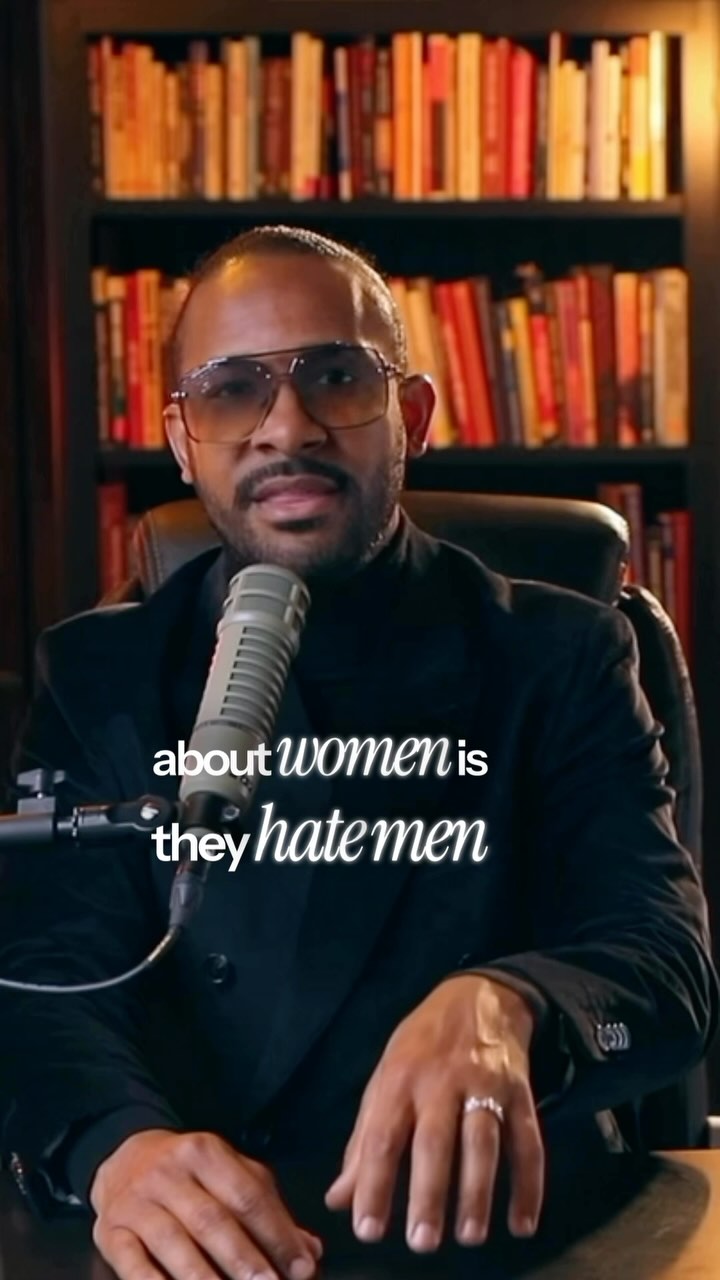 Image shows a man in a suit, glasses, and microphone in front of a bookcase. Text overlayed reads "about women is they hate men."