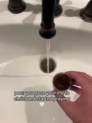 The cover image presents a first-person perspective inside a bathroom sink. A faucet is centered at the top, with clear water streaming down into the drain. A hand on the right holds a small metal cup. The text overlay is also in the image, as well as a small white heart graphic below it.