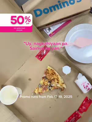 The cover image features an open Domino's pizza box with a slice of pizza prominently displayed. Beside the slice are a small cup with a liquid, a packet, and a small container, likely for sauce. Text overlays include a promotional offer for a 50% discount and a promotional message, and the dates of the offer.