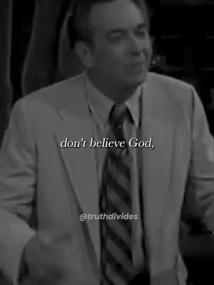 The image is a grayscale shot of a man in a suit and tie speaking. Text overlays are placed near the center of the frame. The background is slightly blurred.
