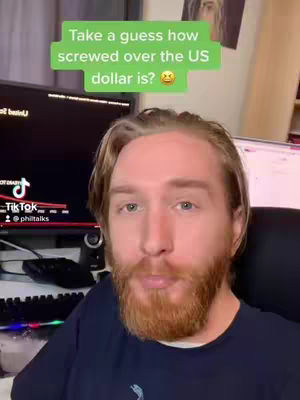 A man with a red beard and blonde hair is the central focus, set against a background of computer screens and a home environment. Overlaid is a green text box with the prompt 'Take a guess how screwed over the US dollar is?'