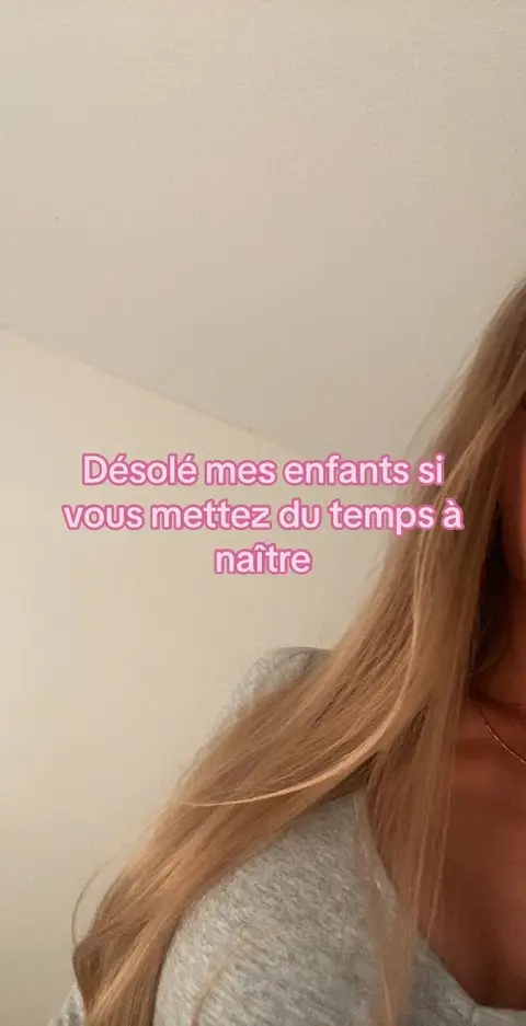 A selfie-style shot featuring a woman with long blonde hair framing part of her face. A pink-toned text overlay is on top with a message. The background appears to be neutral-colored. The composition focuses on the woman and the text.