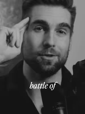 A black and white close-up image of a man looking into a camera, with his index finger pointing towards his temple. Text overlayed on the image reads "battle of".