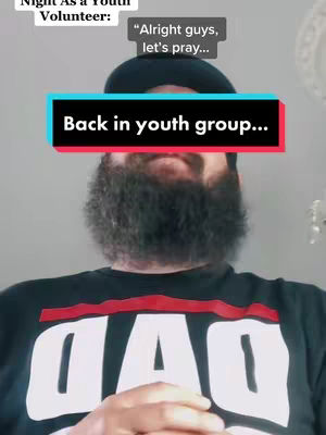 A selfie-style shot featuring a man with a full dark beard and a black cap. Above him, text overlays are positioned to highlight the caption, as well as thought bubbles. The man is wearing a black t-shirt with the word "DAD" in large white letters. The background is plain, appearing to be indoors, contributing to a focus on the man's facial expression.
