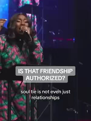A woman with dark hair and a patterned jacket is speaking into a microphone on stage. An overlay reads "Is that friendship authorized?" with more text below.