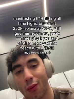 A selfie-style video cover featuring a young man with short dark hair and headphones. He is positioned with the camera angled from slightly below, showing his face and upper chest. The background is minimalistic, suggesting an interior setting. Text overlayed at the top of the image lists financial goals such as ETH hitting all time highs, bitcoin at 250k, solana at $300 with other phrases such as chill guy memecoin era printed money on the beach with a 10/10 and (my portfolio is rinsed).