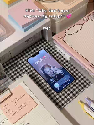 An overhead shot shows a phone, with a picture of a person named Rosé on the screen, lying on a checkered surface. Surrounding the phone are various stationery items, including notepads and pens. The image is bathed in natural lighting with a soft, neutral color palette.