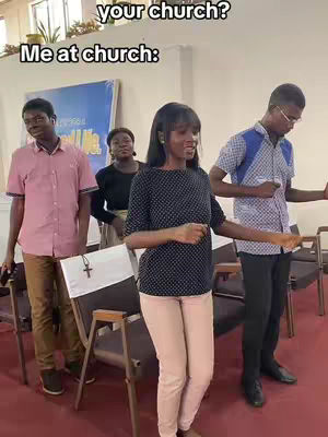 People standing in a church setting, several people in the background. The main person is a young woman in the foreground, dancing with her arms out. The video has text at the top.