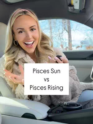 A woman with blonde hair and a pink headband is sitting in a car, smiling at the camera while holding a piece of paper with text. The background shows a snowy outdoor scene visible through the car window.