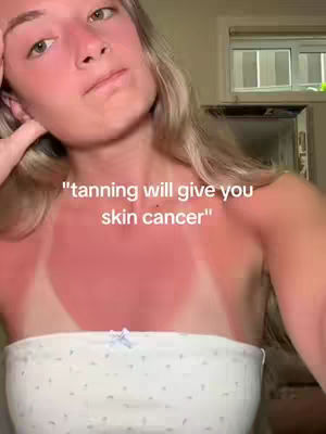 A selfie-style shot showing a woman with heavily sunburned skin and sharp tan lines. The colors are vibrant, particularly the red of the sunburn and the contrast with the white top she is wearing. The composition focuses on her upper body, with text overlaid on the image.