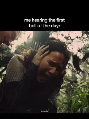 The image shows a scene from a movie where a person is visibly distressed, with hands over their ears, conveying a strong emotional reaction. The background suggests a natural environment.
