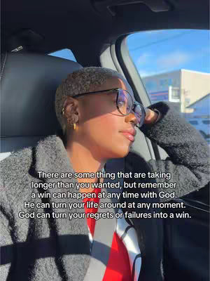 A woman with short, gray hair and glasses is seated in a car near a window. Text overlays the image, and she appears to be looking out the window with a contemplative expression. The lighting suggests it's daytime.
