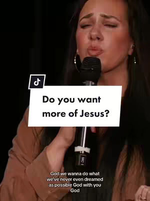 The cover image shows a medium shot of a woman with long dark hair holding a microphone. She has her eyes closed and lips slightly parted as if she is singing or speaking passionately. A white rectangular overlay with the question 'Do you want more of Jesus?' is over her. The TikTok logo is in the upper left corner.