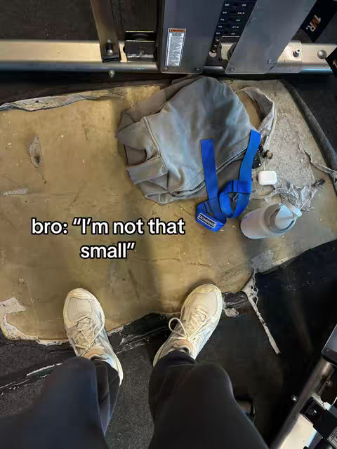 An overhead shot inside a gym setting, showing the floor, some equipment, and a person's legs with shoes and a hoodie. Text overlays the image.