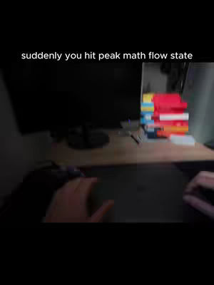 The cover image is a low-angle shot of a desk with a computer monitor and a stack of books. The foreground shows hands interacting with the desk. The background is dark, suggesting a dimly lit room. A text overlay appears at the top.