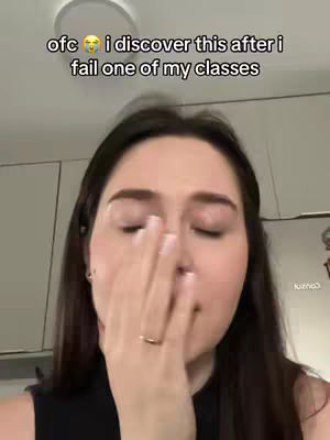 A woman is shown close up, covering her face with her hand, suggesting distress. The composition is simple, focused on her expression with a soft lighting. The background is plain, keeping the attention on the woman.