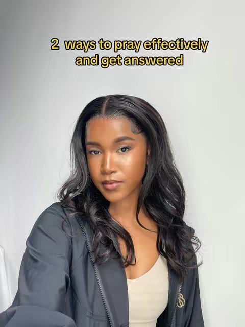 A medium shot features a Black woman with long, wavy black hair, looking directly at the camera. She's wearing a black jacket over a beige top. The background is a plain, light-colored wall. Text in yellow font at the top says, '2 ways to pray effectively and get answered.'