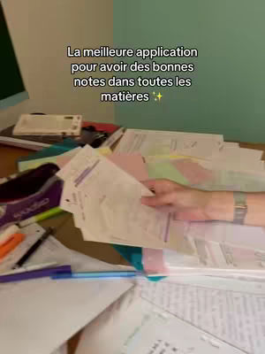 The cover image shows a desk covered with papers and a person's hand holding some of the papers. Beside the desktop, there is a teal-colored wall. The text overlay indicates this video promotes an app for education.
