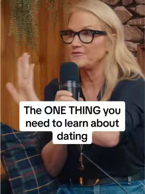 A woman with blonde hair wearing glasses and a black shirt speaks into a microphone. Text overlay in a white box reads 'The ONE THING you need to learn about dating'.