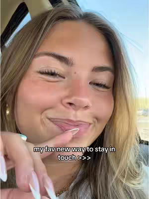 A selfie of a young woman in a car, with her smiling and looking to the side. Her index finger touches her lips. Text overlay is displayed across the bottom.