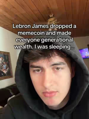 A selfie-style video with the creator in a black hoodie, looking at the camera with a neutral expression. Behind the creator is a wooden ceiling and a framed picture hanging on the wall. Text overlayed on the top of the image states a humorous scenario related to a memecoin.