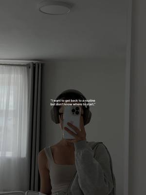 A person is reflected in a mirror, holding a phone up to their face and wearing headphones with a gray hoodie. The text overlayed is in white.