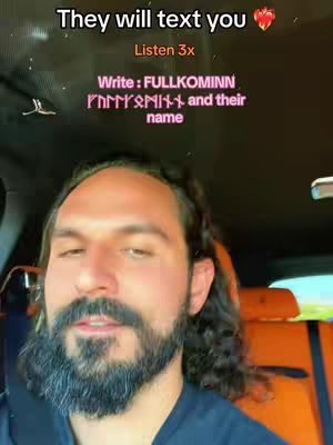 A man with a beard in a car. Text overlays with a message and language in the top left corner. The car interior has an orange seat visible.