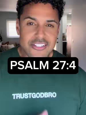 A man with short, dark hair and a warm expression is centered in the frame, wearing a green t-shirt. A black rectangle with white text 'PSALM 27:4' overlays the image. Behind him, a room with a window, a couch, and a glimpse of kitchen area is visible.