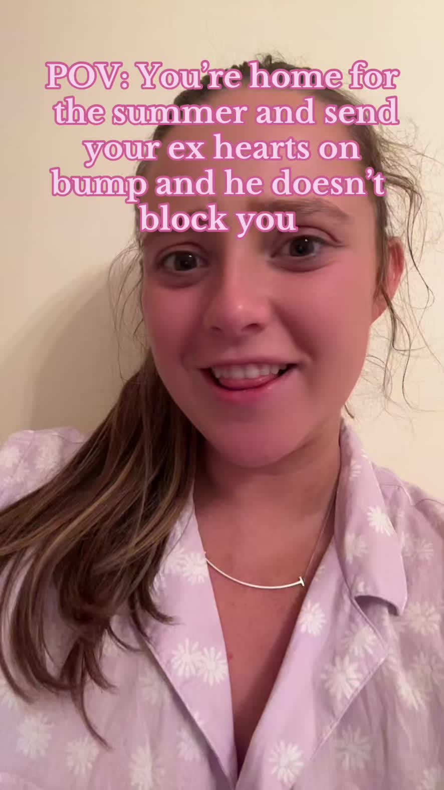 The cover image is a selfie featuring a young woman with light skin, brown hair pulled back in a ponytail, and a light purple floral shirt. The text overlay says: POV: You're home for the summer and send your ex hearts on bump and he doesn't block you. She is smiling and looking at the camera with her tongue slightly out.