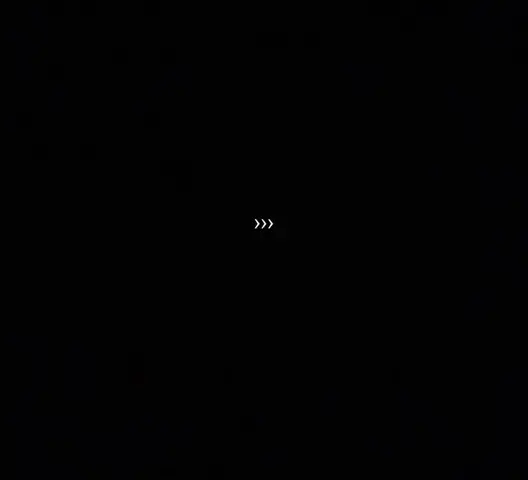 A completely black image with three white chevrons pointing to the right.