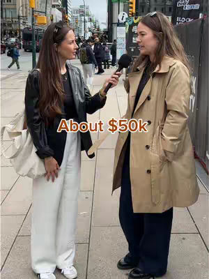 Two women are shown in a street setting, likely conducting an interview. The woman on the left is holding a microphone and speaking, while the woman on the right is listening. The image is bright and the background reveals a city environment.